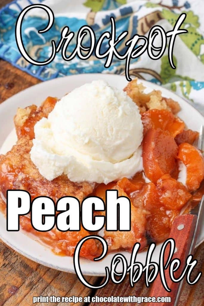 peach cobbler on small white plate with wooden handled fork next to blue floral napkin