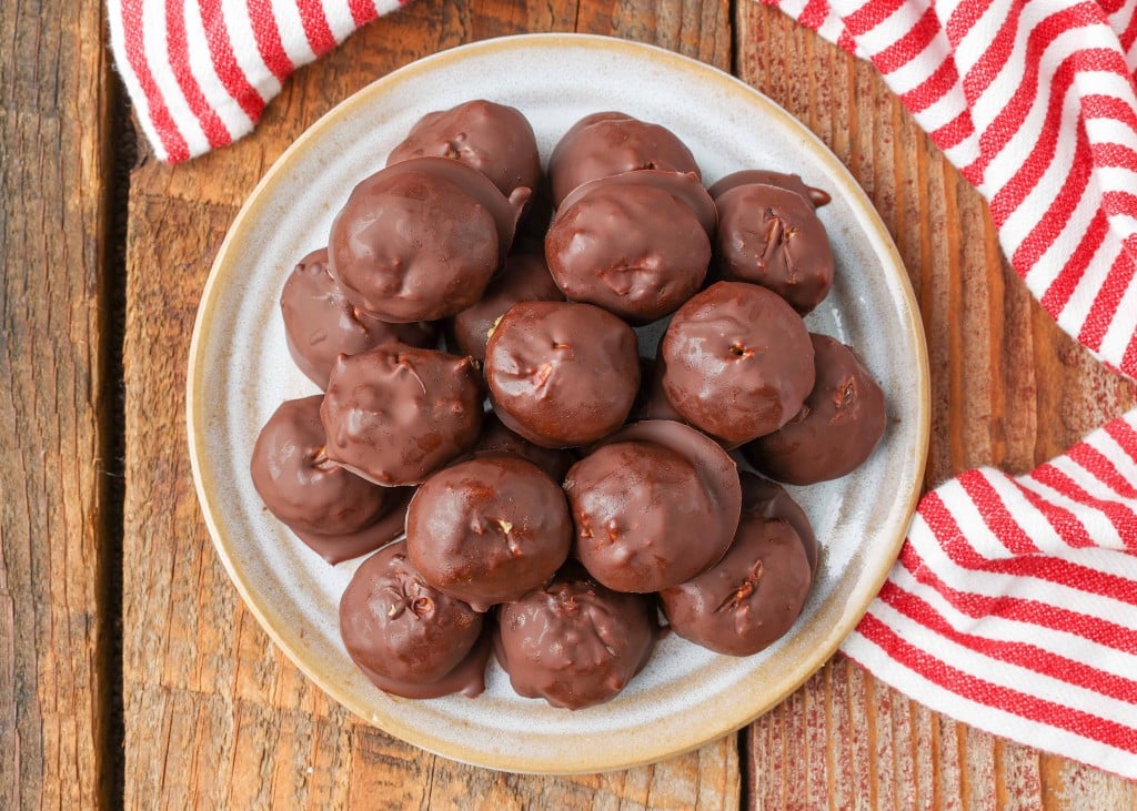 Overhead shot of Peanut Butter Balls with cornflakes inside on wooden table with red napkin