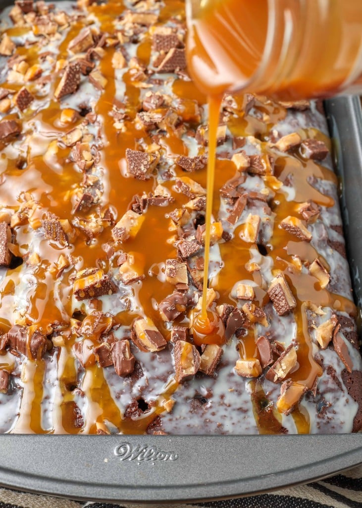 caramel sauce is being poured over the chocolate cake in this image.