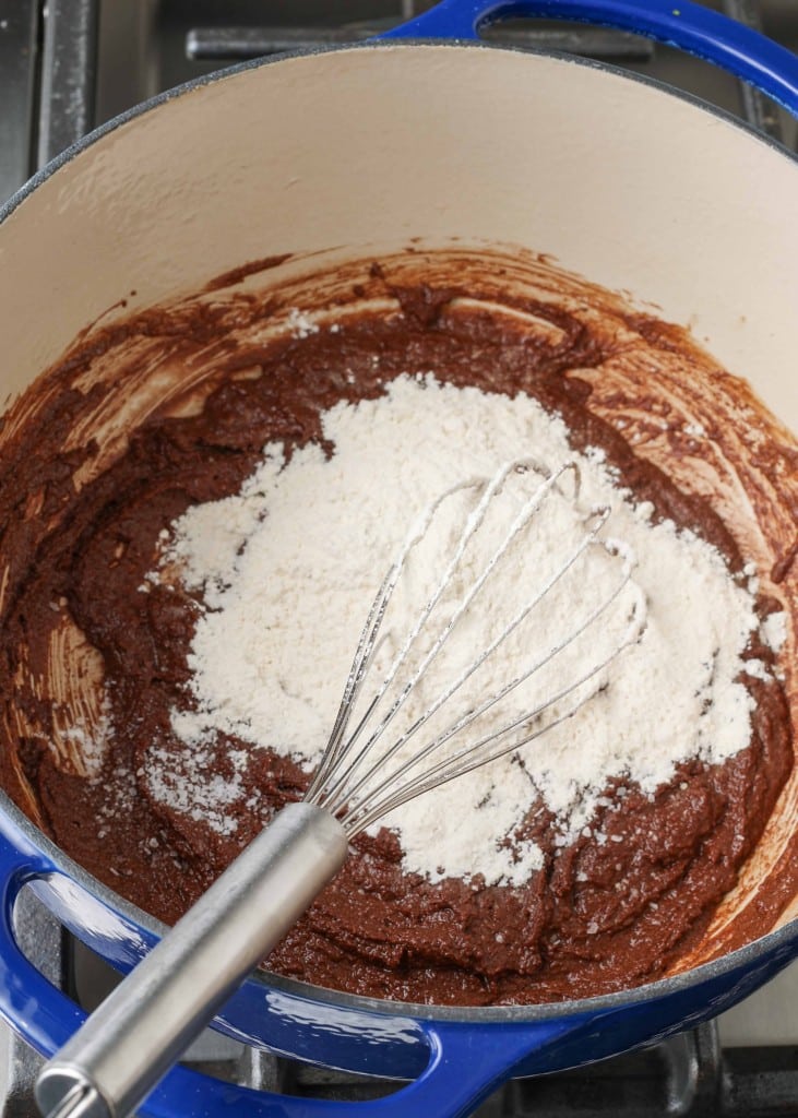 Melted chocolate and flour in blue dish with silver whisk