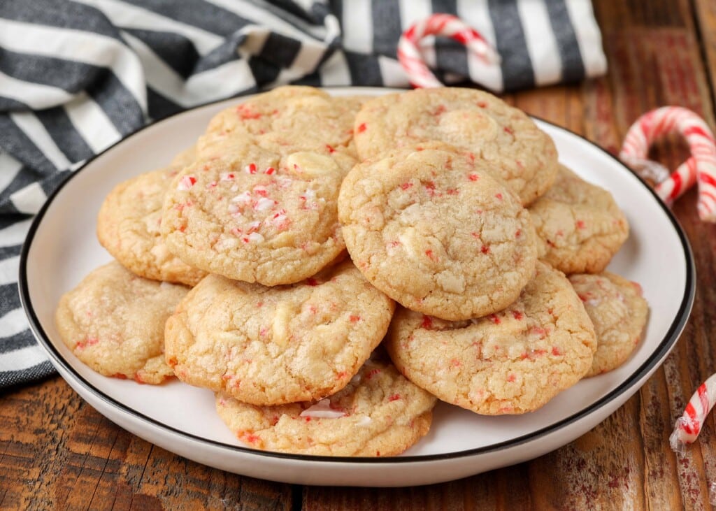 cookies with white chocolate and crushed candy canes on white plate with black rim