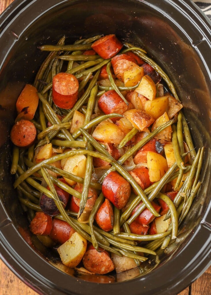 Vertical shot of potatoes, kielbasa, and green beans in slow cooker