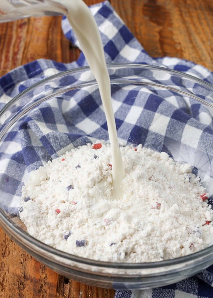 Mixing together muffin mix and milk in a glass bowl