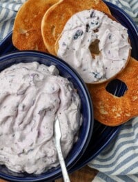 close up of berry cream with knife and bagels