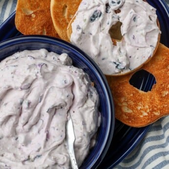 close up of berry cream with knife and bagels