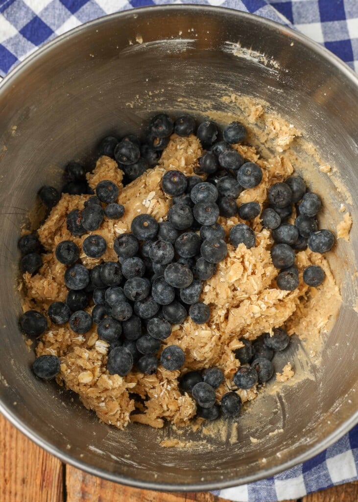 Blueberries have been tossed into the bowl and are ready to be stirred into the dough.