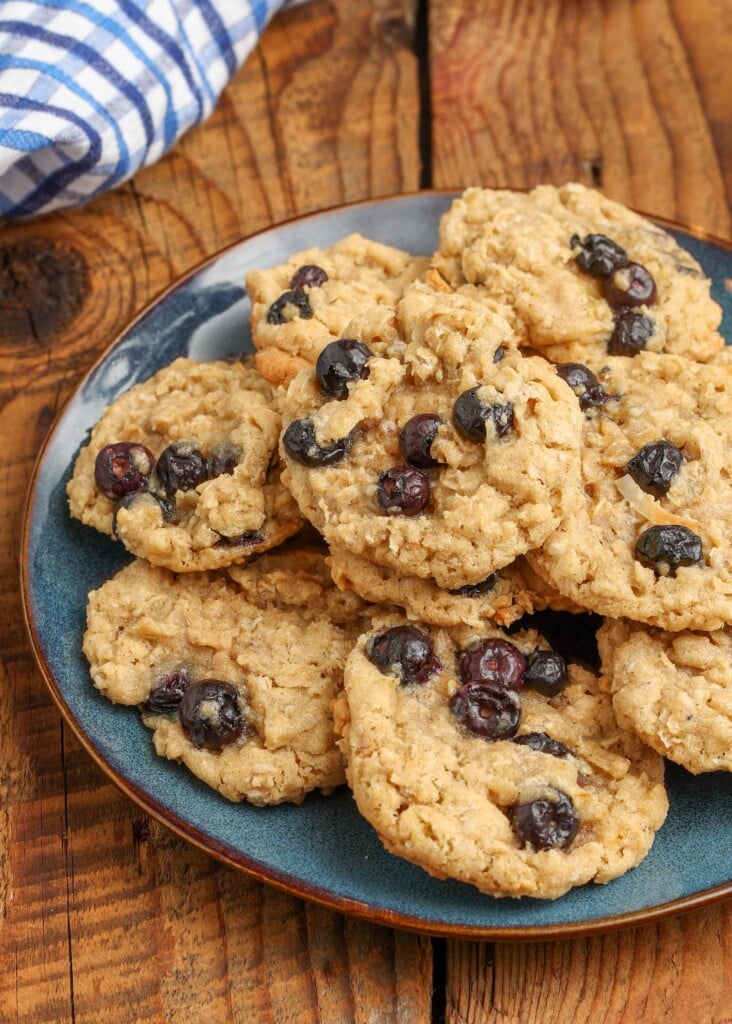 Blueberry oatmeal cookies on a blue plate on a wooden tabletop.