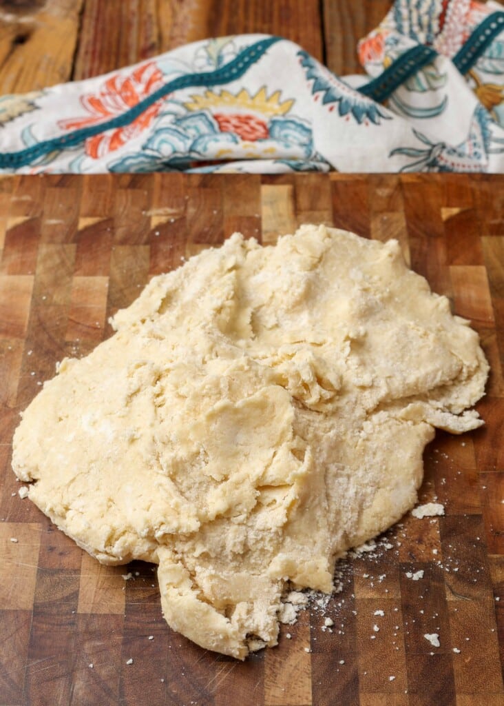 The dough has been turned out onto a wooden surface to knead.