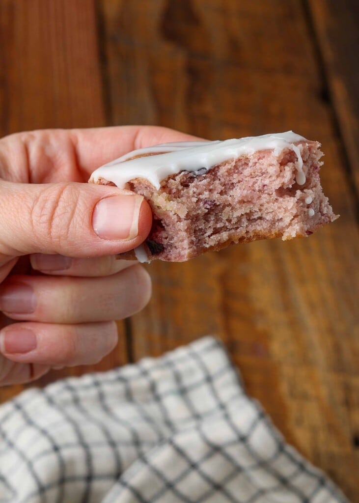 hand holding piece of cake with bite out of it
