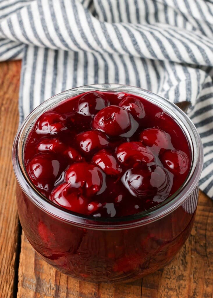 jar filled with cherry pie filling on wooden table