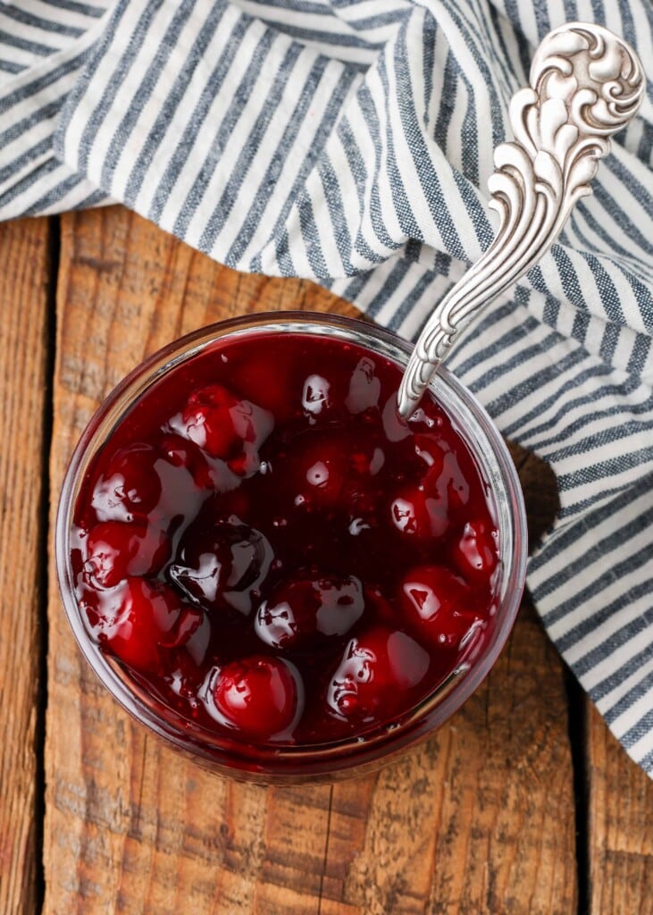 overhead shot of cherry sauce in jar with curvy ladle