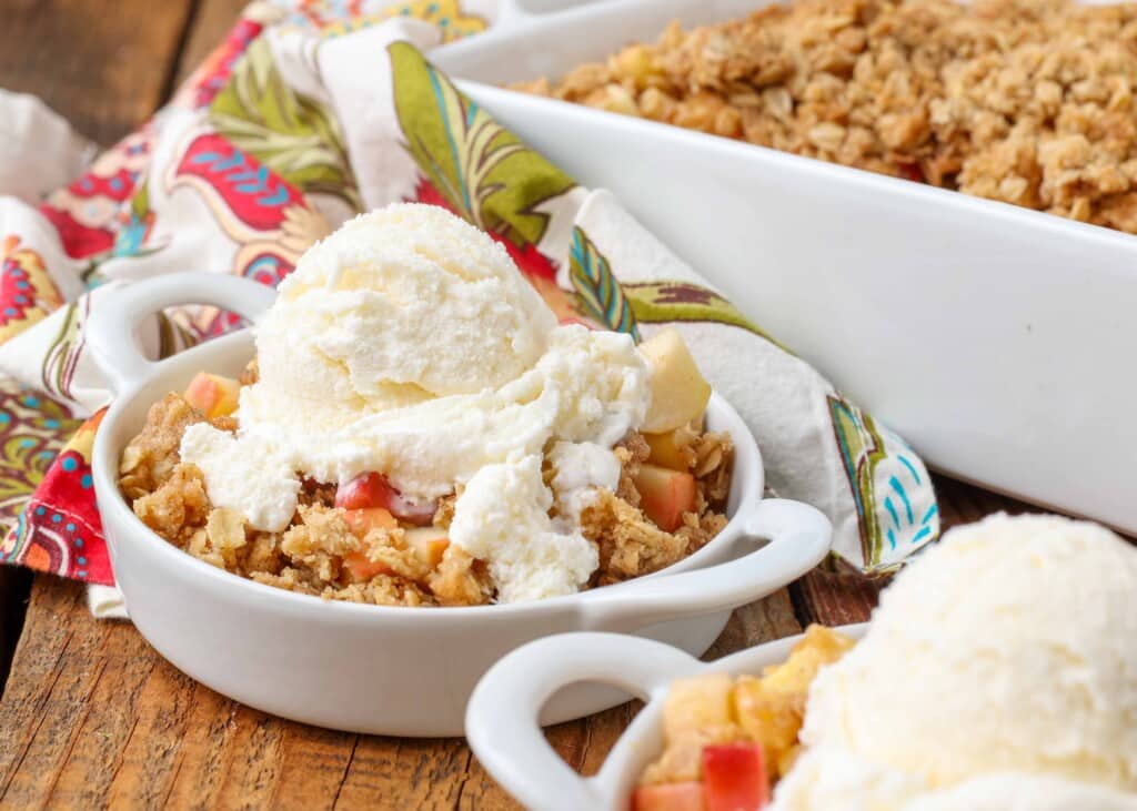 rhubarb crisp with apples in small white dishes with ice cream on top