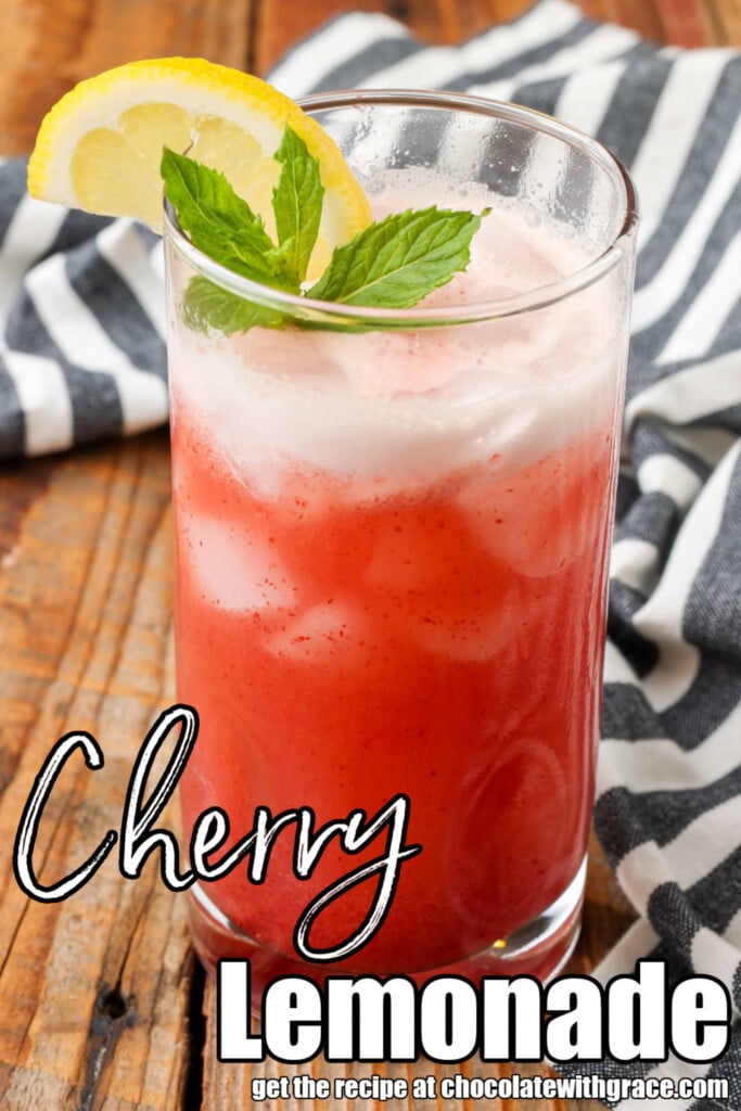 close up photo of lemonade with cherries, lemon wedge, and mint