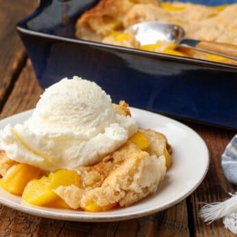 horizontal photo of cobbler with ice cream on white plate