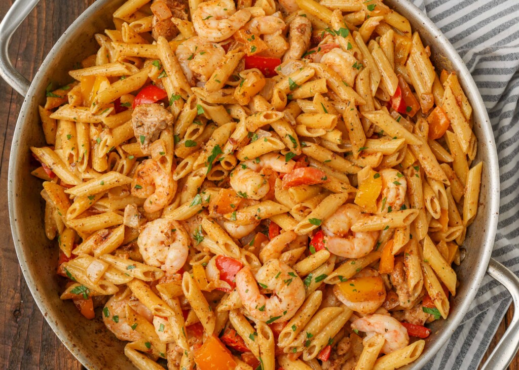 Overhead close-up horizontal shot of creamy pasta with shrimp and bell peppers