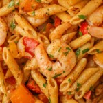 Overhead close-up shot of creamy pasta with shrimp and bell peppers