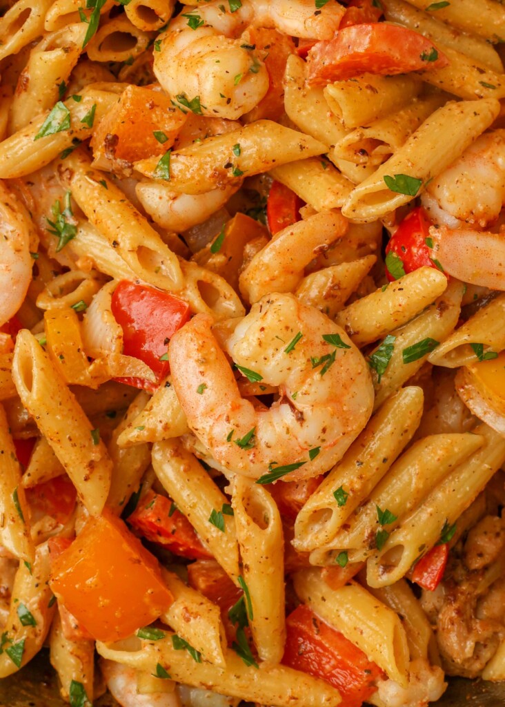 Overhead close-up shot of creamy pasta with shrimp and bell peppers