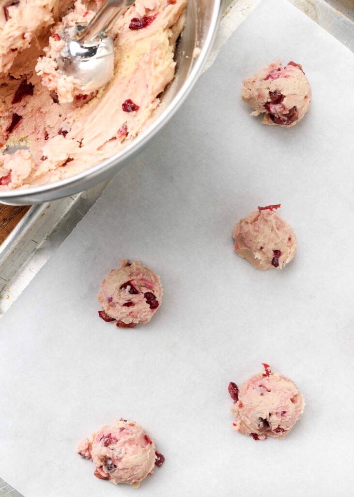 cherry cookie dough mounds on a parchment lined pan