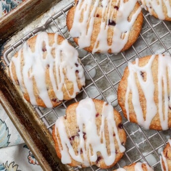 Soft cherry cookies on a rack over a pan with glaze drizzled over the top