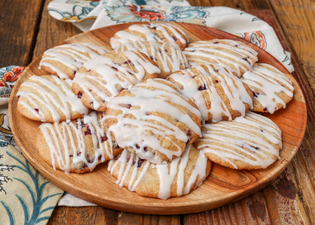 Soft cherry cookies on a rack over a pan with glaze drizzled over the top