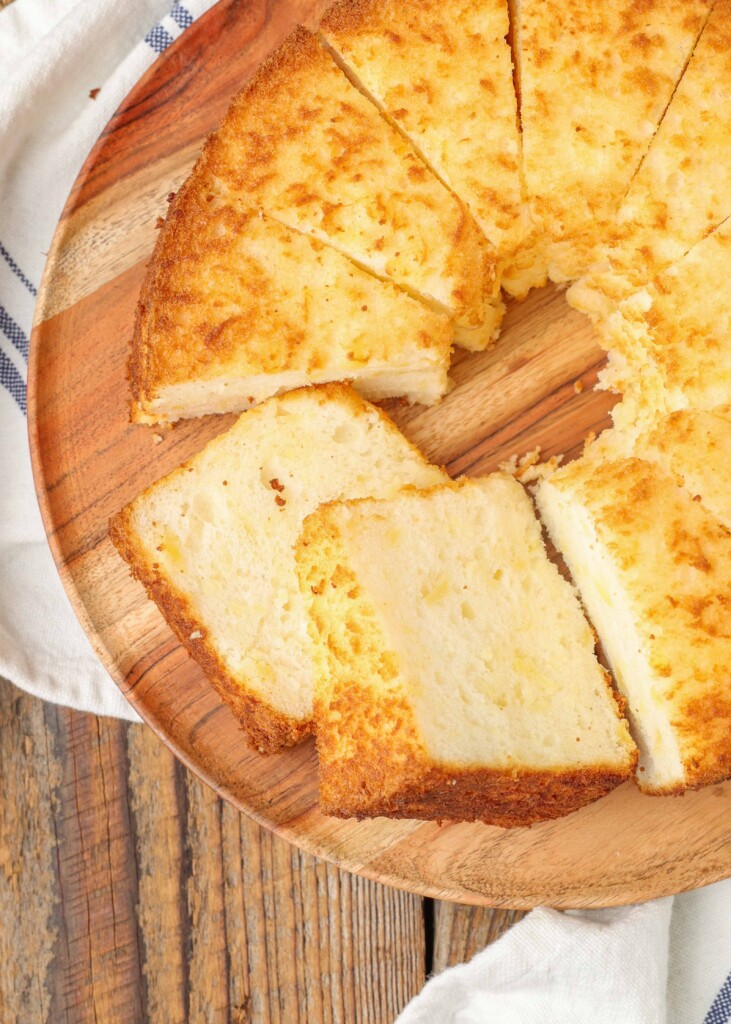 sliced pineapple angel food cake on a wooden cutting board