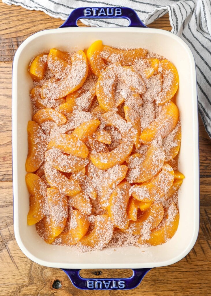 canned peaches topped with cinnamon sugar mixture in baking dish