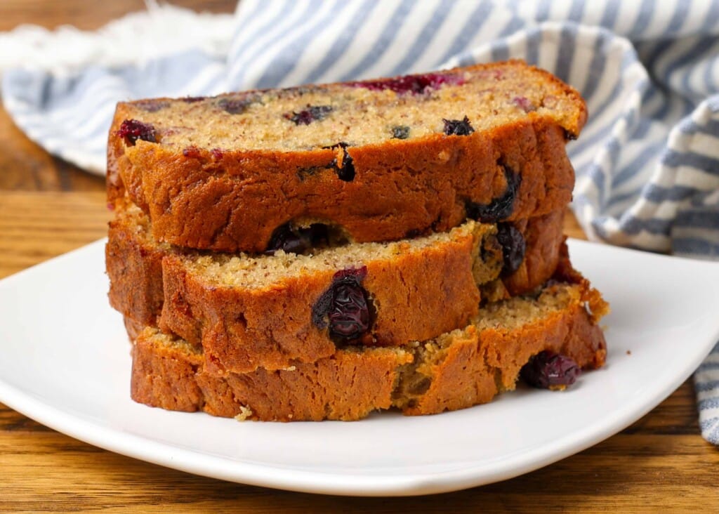 slices of banana bread on plate with striped towel