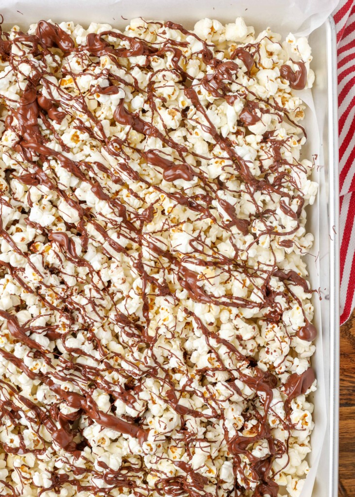 chocolate drizzled popcorn on a pan