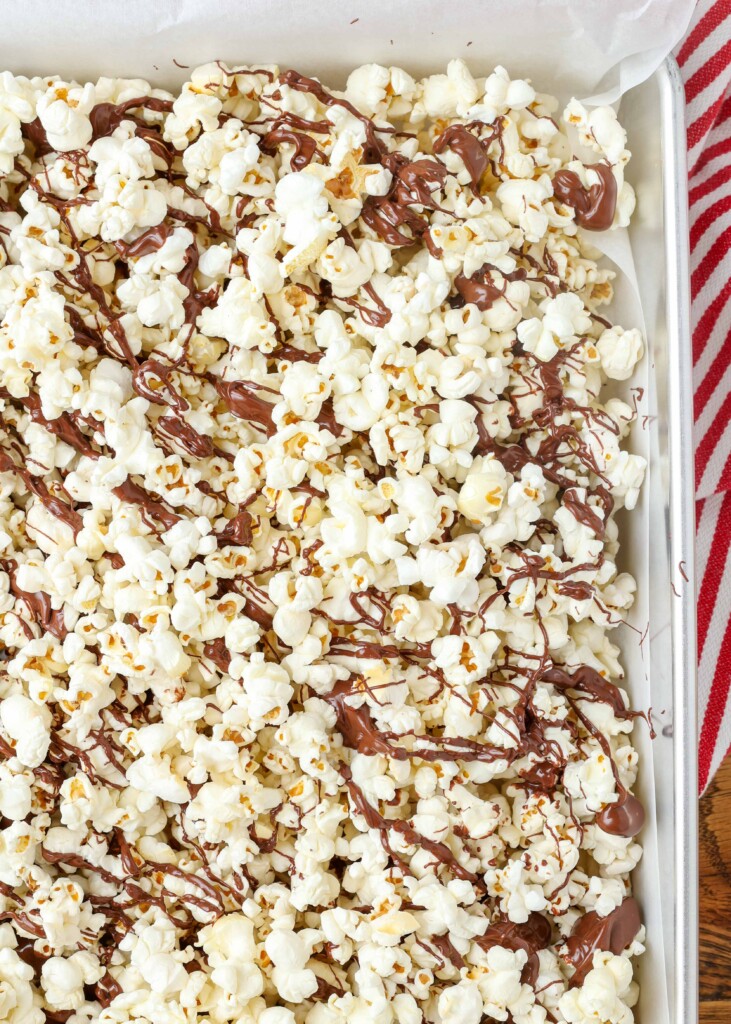 chocolate drizzled popcorn on a pan