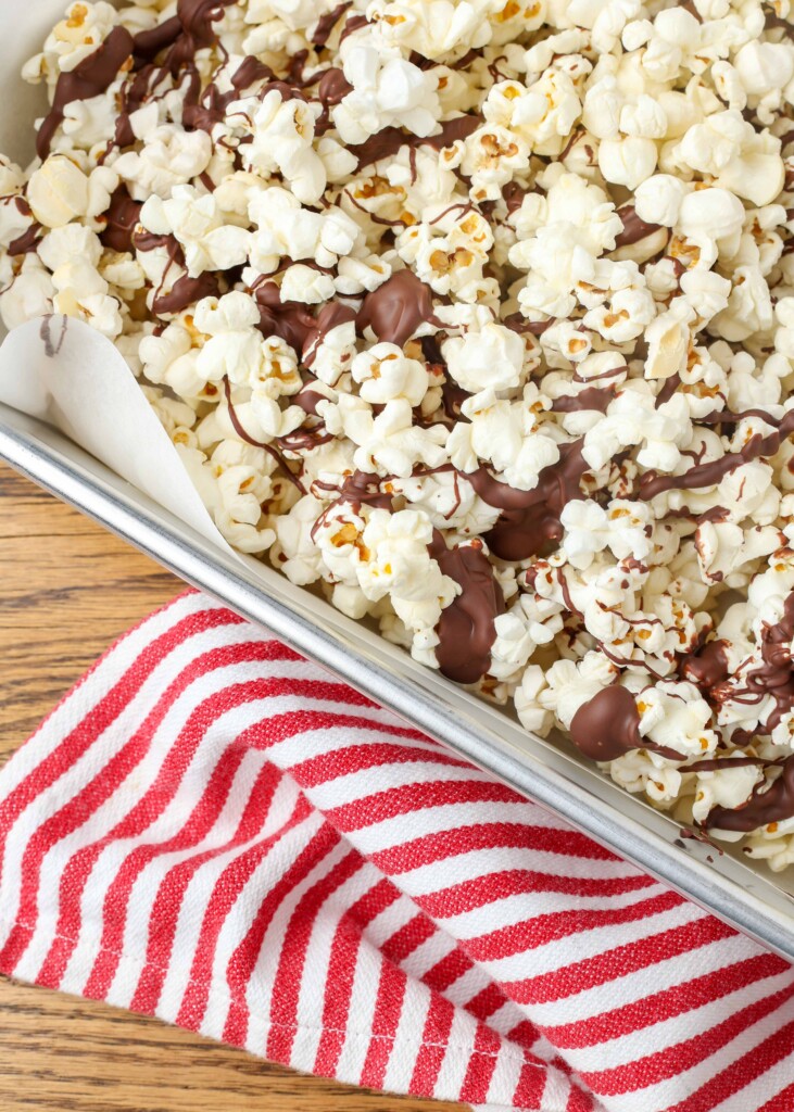 chocolate drizzled popcorn on a pan