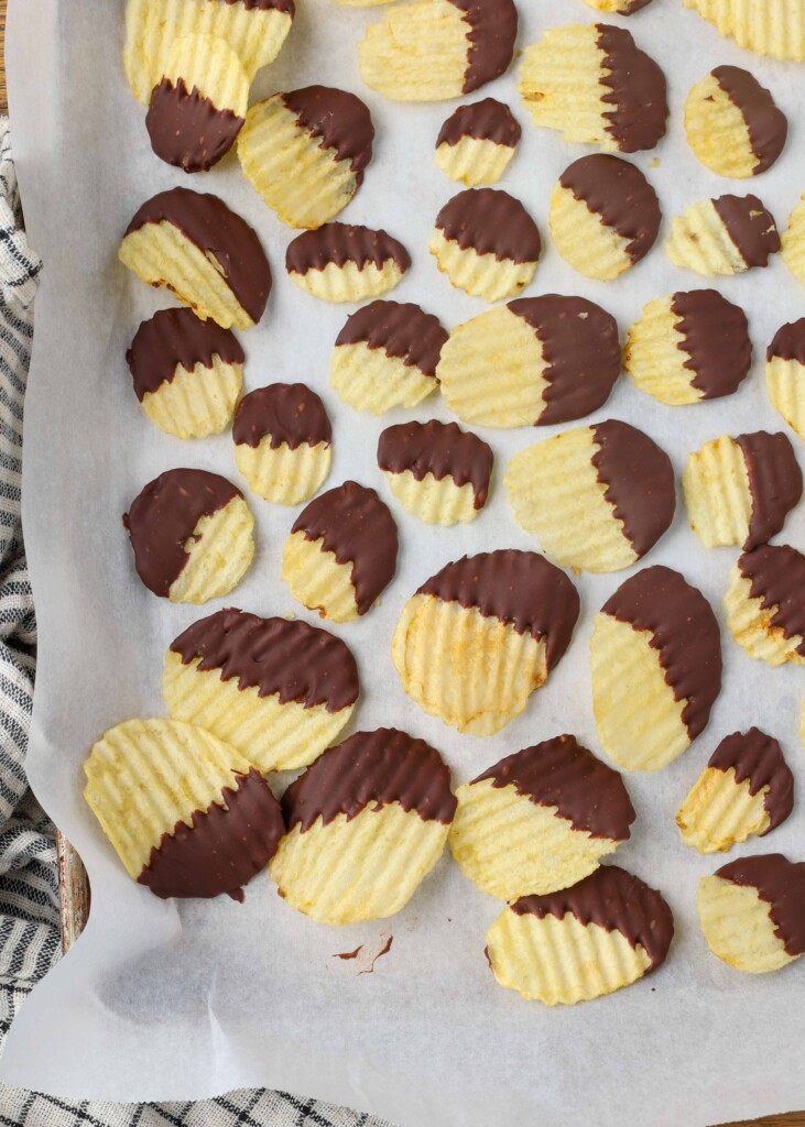 chocolate dipped potato chips on parchment paper