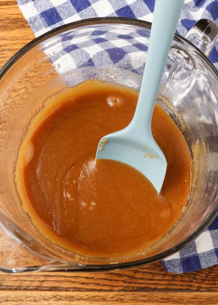 brown sugar melted into butter in a glass bowl with a silicone spatula