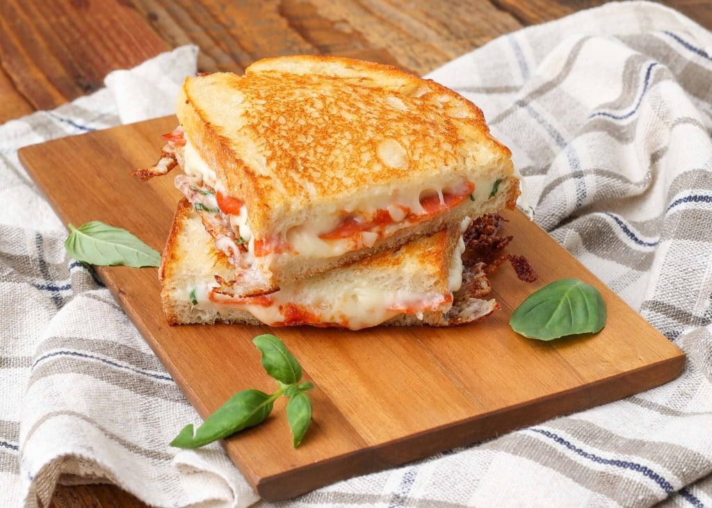 Pepperoni filled grilled cheese sandwich on cutting board
