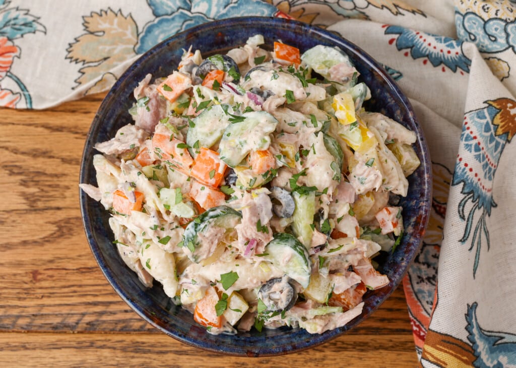 black bowl holding pasta salad on wooden table