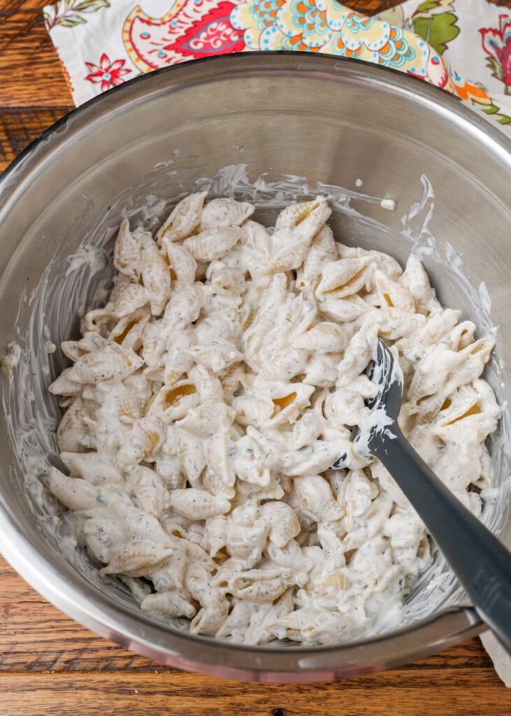 pasta tossed in creamy pickle dressing in metal bowl