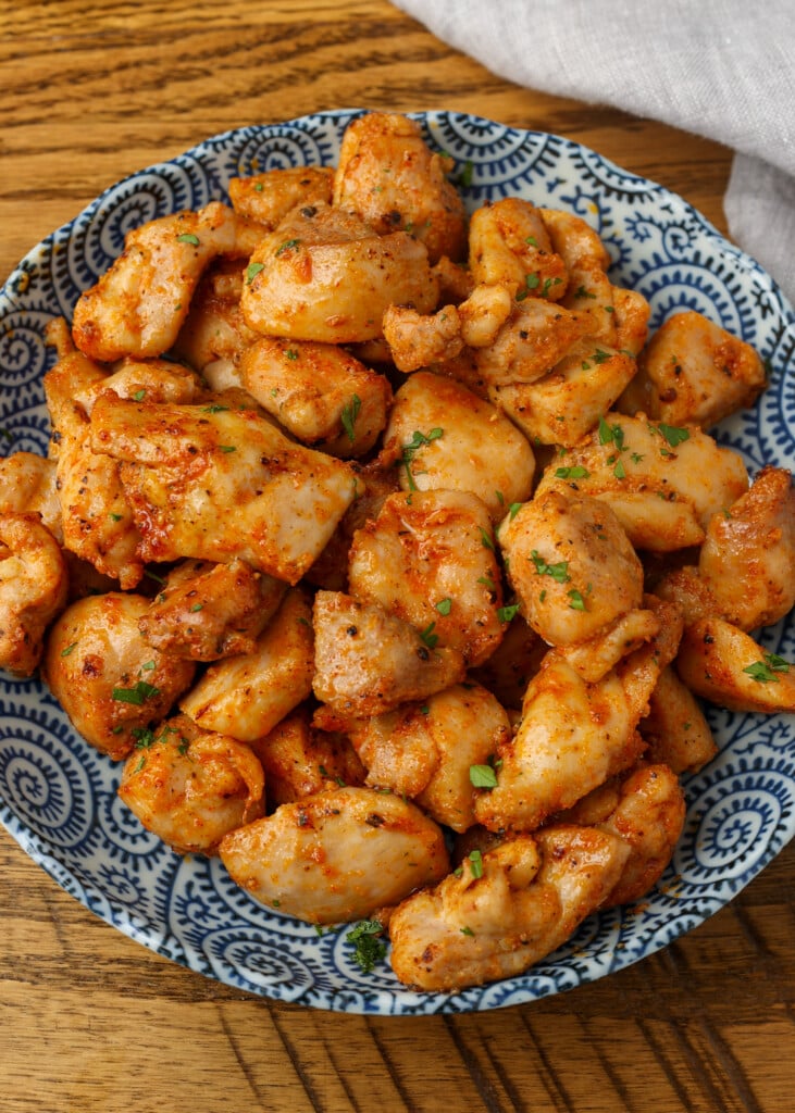 overhead shot of chicken bites in shallow blue bowl
