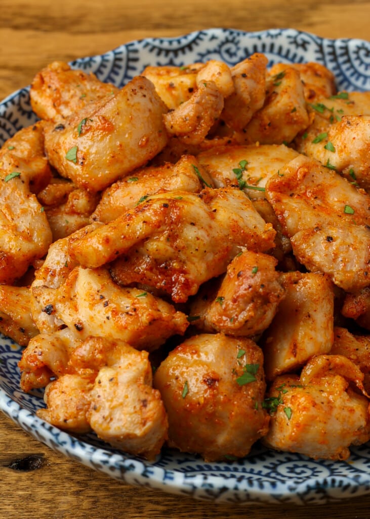 close up photo of chicken pieces in blue bowl