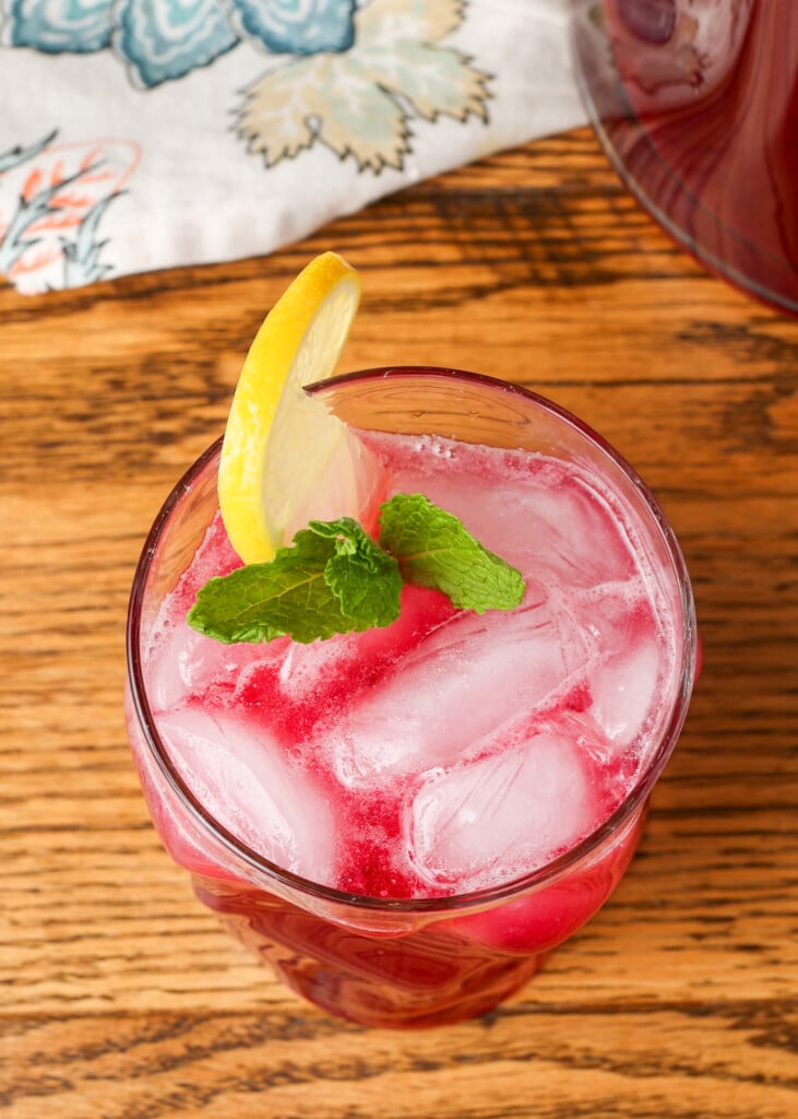 blueberry lemonade in a glass garnished with lemon and mint