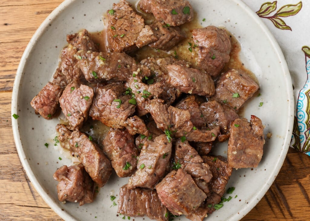 horizontal photo of steak bites on pottery plate