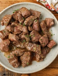 bite size pieces of steak on plate with butter sauce