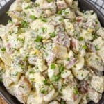 horizontal close up photo of potato salad in black bowl