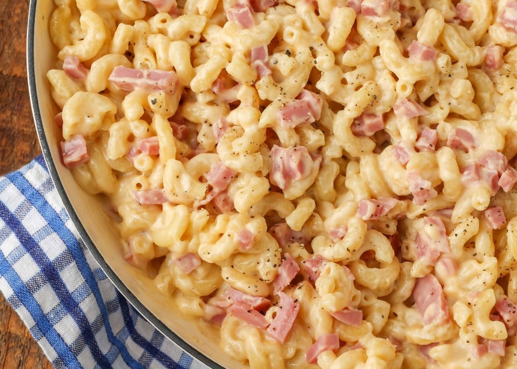 A close up photo of creamy mac and cheese with ham.