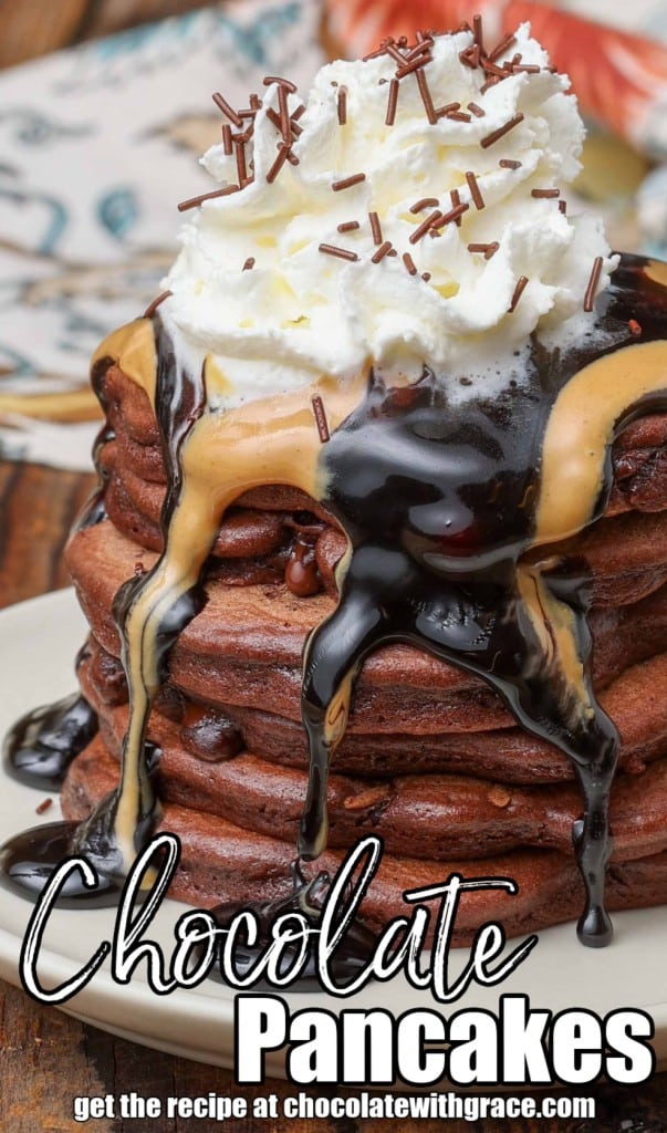 Fluffy chocolate pancakes with peanut butter and chocolate sauce and whipped cream on top