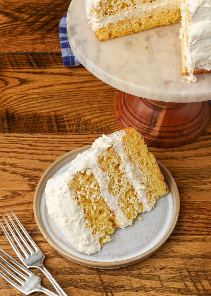 slice of cake on table next to cake stand