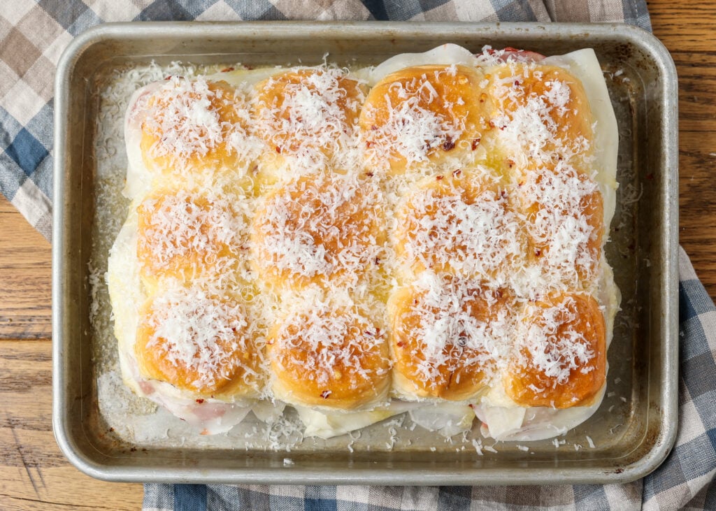 A horizontally aligned image of the completely prepared chicken parm sliders, ready to go into the oven.