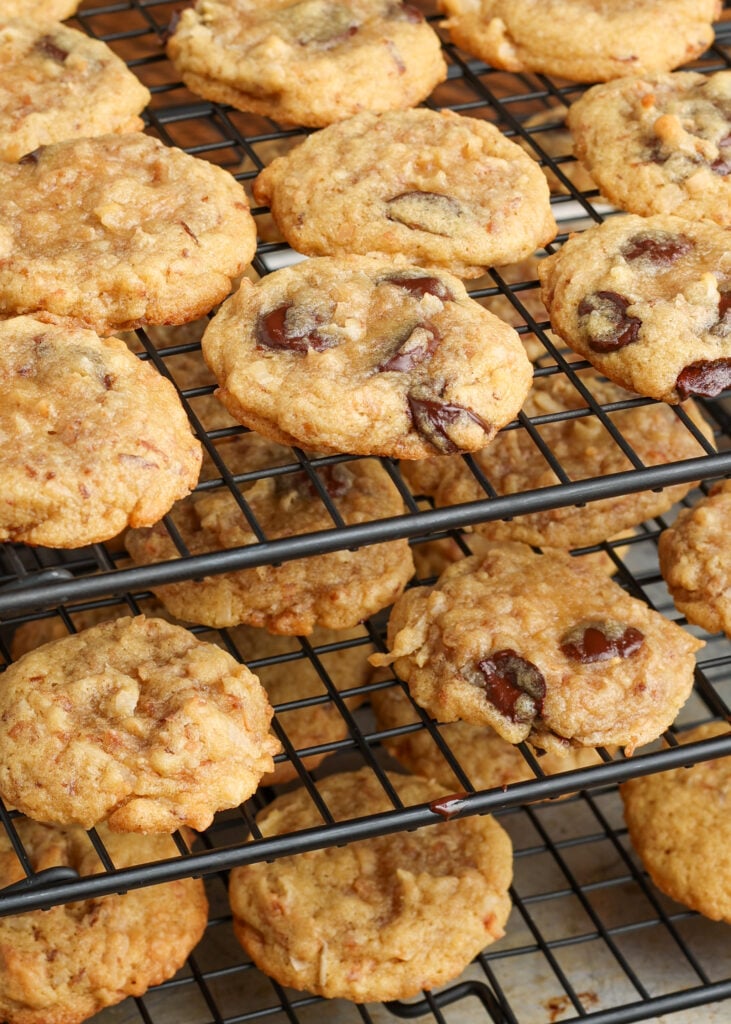 Coconut cookies (some with chocolate chips) cool on a multi-level wire rack.