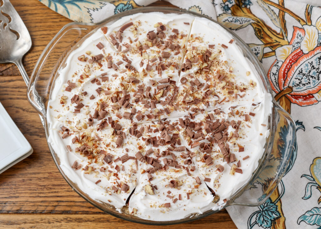 A horizontally aligned top down close up of the possum pie, finished with crushed nuts and shaved chocolate.