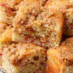 A close up photo of the edge of a slice of coffee cake with rhubarb pieces visible.