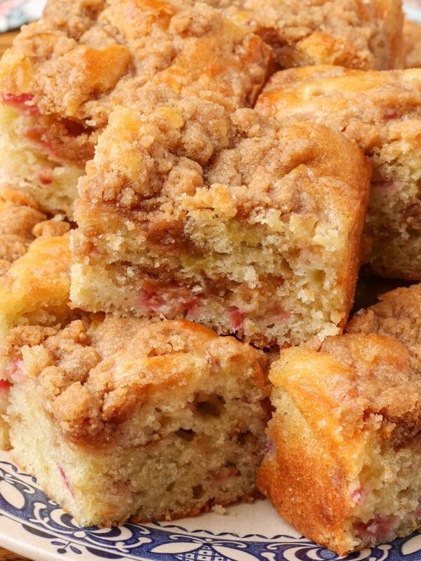 A close up photo of the edge of a slice of coffee cake with rhubarb pieces visible.