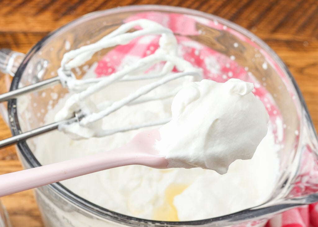 whipped cream in bowl with beaters